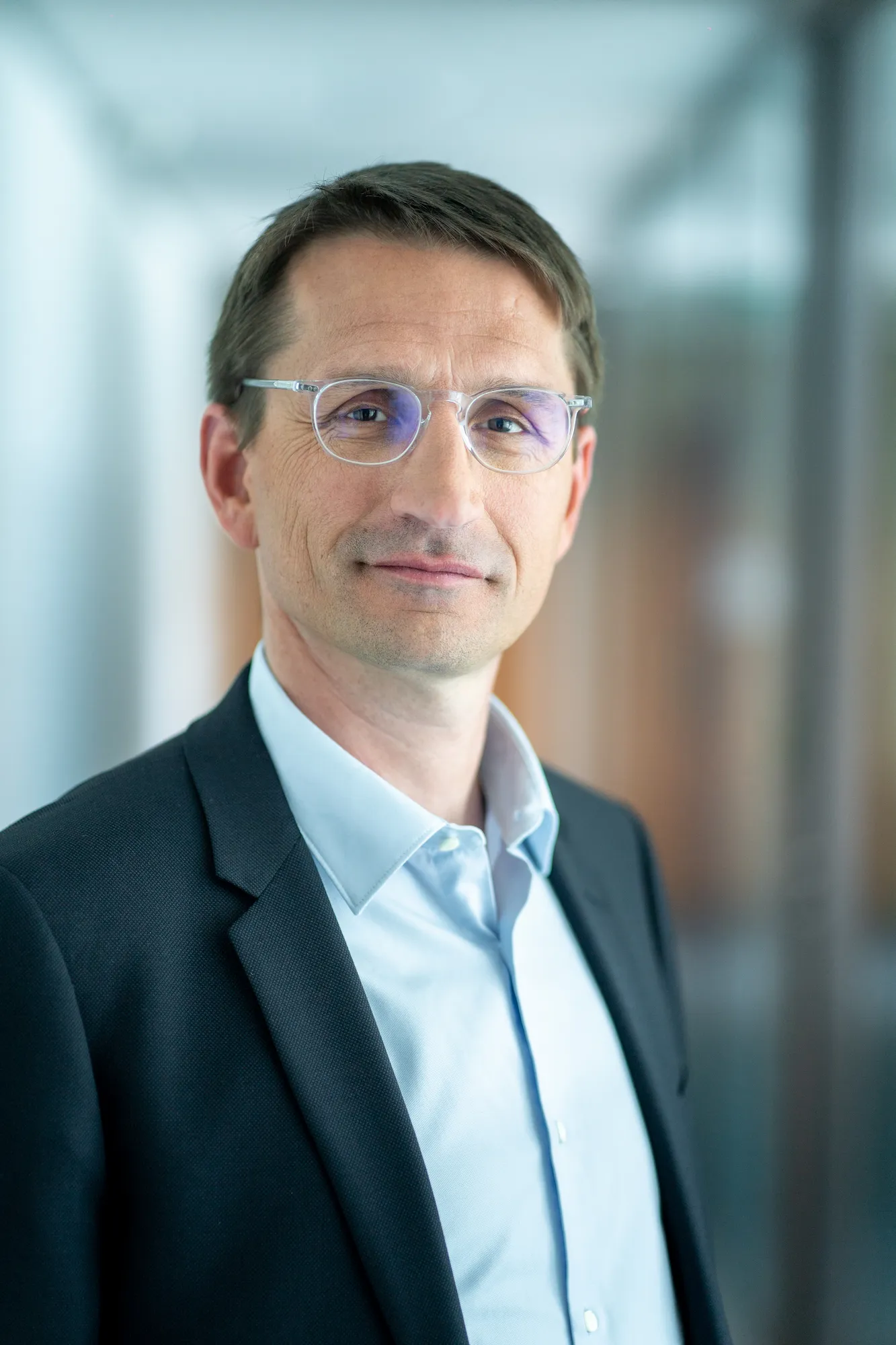 portrait professionnel femme en veste marine façade extérieure La Défense